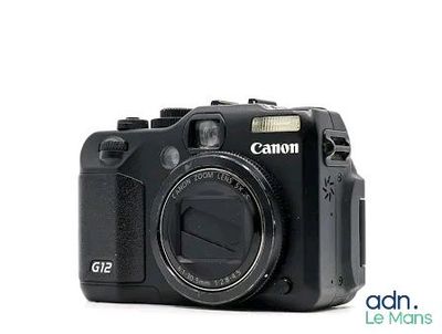 a black digital camera sitting on a white surface