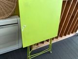 une armoire verte et un panier en osier posé par terre