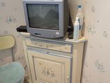 une petite télévision posée sur un meuble, dans un coin de la pièce