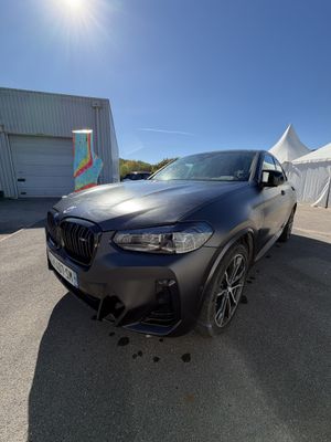 La BMW X4 est garée devant une tente