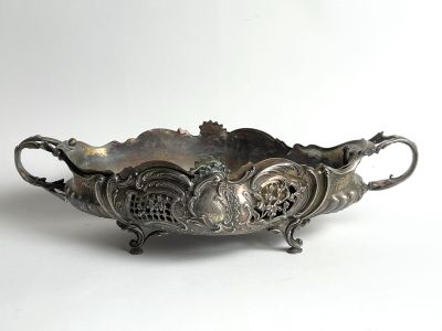 an antique silver plate with a decorative design on it
