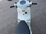 un scooter blanc garé sur le bord de la route
