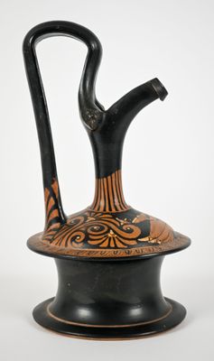 a black and orange vase with a handle on top of it