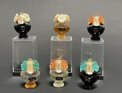 four glass vases with different colored flowers in them on a gray surface