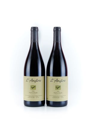 deux bouteilles de vin rouge posées l'une à côté de l'autre sur une surface blanche