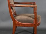 an old wooden chair with a brown upholstered seat