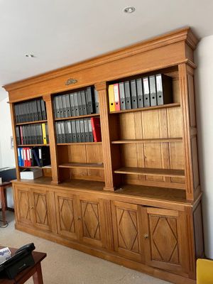 a large wooden bookcase in the middle of a living room