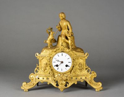 une horloge en or sur laquelle figurent un homme et un chien