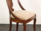 an image of a wooden chair with a beige cushion on it