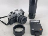 un appareil photo, un objectif et une clé USB, placés les uns à côté des autres