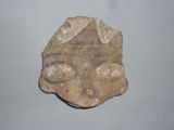 a small piece of pottery with a face on it