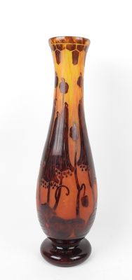 un vase en verre marron et orange posé sur un socle en bois