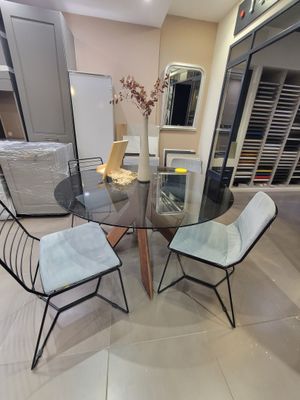 une table en verre avec des chaises et un vase posé dessus