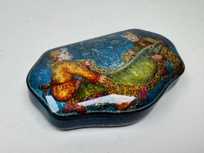 a small box with a painting on it on a table