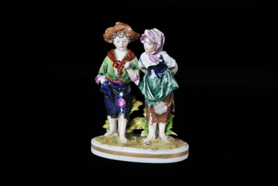 une figurine représentant deux personnes debout l'une à côté de l'autre
