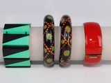 trois bracelets de couleurs différentes posés sur une serviette, elle-même posée sur une surface blanche