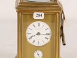 a gold clock that is sitting on a white surface