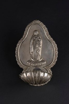 une image représentant une cuillère en argent sur laquelle figure la statue d'une femme