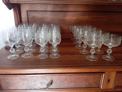 a lot of wine glasses sitting on top of a dresser