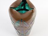 a brown vase with a green glass inside of it