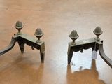 pair of antique iron candlesticks with pinecones on top of them