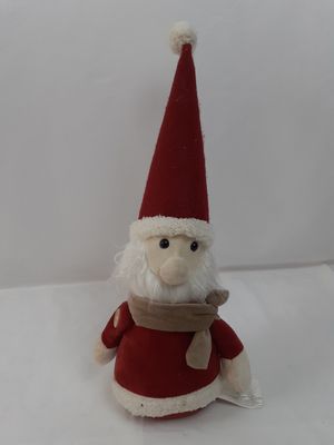 a small stuffed santa claus sitting on a white surface