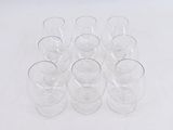 six empty glasses sitting on a white surface with a white background