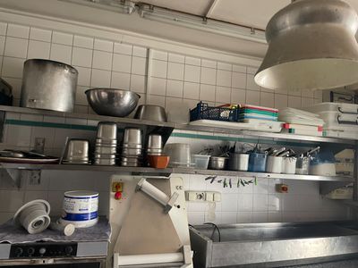 une cuisine avec beaucoup de casseroles et de poêles sur les étagères