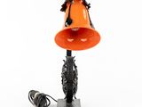 a close up of a lamp with an orange shade on it
