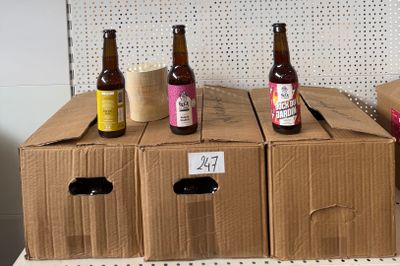 Plusieurs caisses de bière sont empilées sur une étagère dans un magasin.