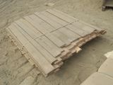 un tas de bois posé par terre, dans le sable