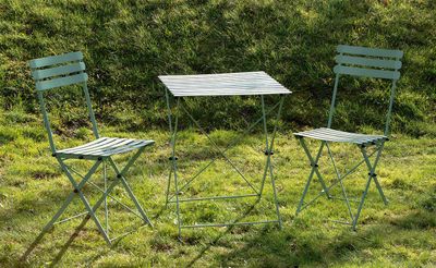 deux chaises et une table posées sur l'herbe dans le jardin