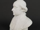white marble bust of a man on a black background