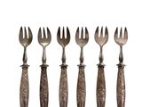 six forks and spoons are lined up on a white surface