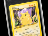 La carte Pokémon se trouve dans un étui en plastique transparent sur fond noir.
