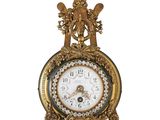 une horloge en or posée sur une surface blanche