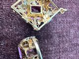 deux bijoux posés sur un tissu violet