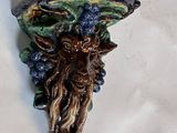 une applique murale ornée de grappes de raisin sur un fond blanc