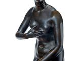 statue of a woman holding a flower in her right hand