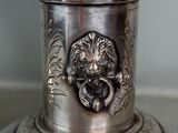 a silver plate with a lion head on it