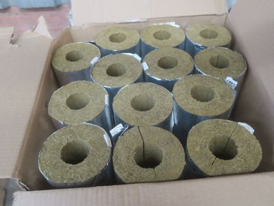 de nombreux rouleaux de ciment dans une caisse posée par terre