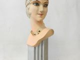 bust of a woman wearing a head scarf on top of a metal stand