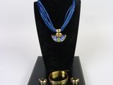 necklace, bracelet, and ring set on display on a black stand