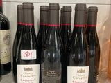 several bottles of wine are lined up on a counter