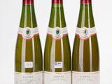 three bottles of wine are lined up on a white surface