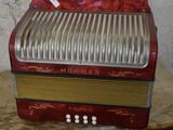 a red accordion sitting on top of a wooden table