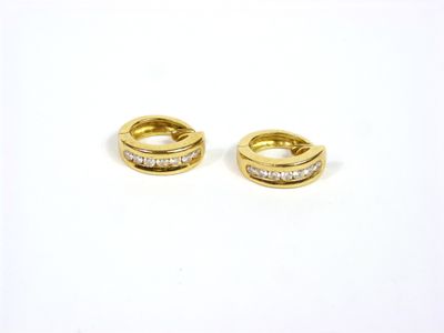 une paire de boucles d'oreilles en or et diamants sur fond blanc