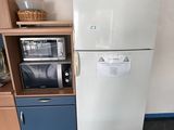 un réfrigérateur blanc et un micro-ondes dans une petite pièce