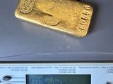 un lingot d'or posé sur une calculatrice