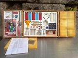 une boîte en bois posée sur une table et contenant divers objets